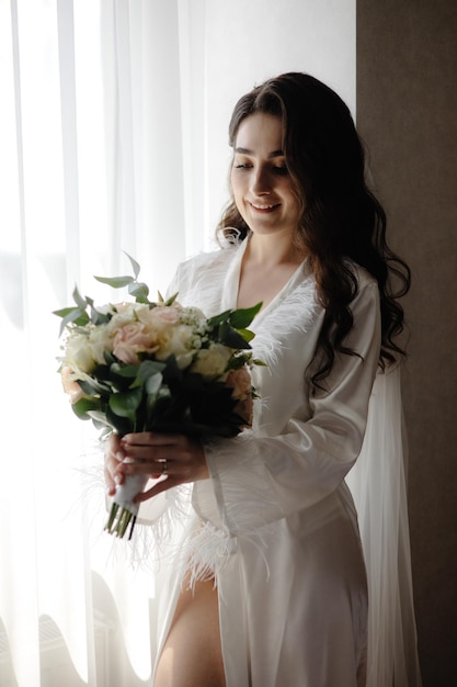 A bride holds a bouquet of flowers in her hand.