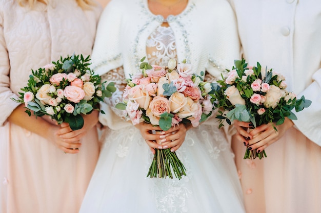 The bride holds a wedding bouquet in her hands