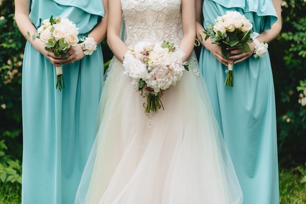 The bride holds a wedding bouquet in her hands