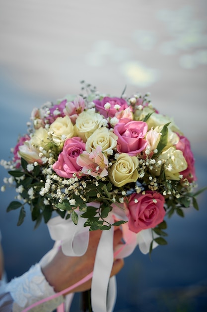 The bride holds a wedding bouquet in her hands