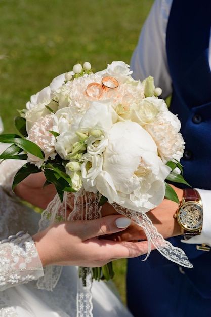 The bride is holding a bouquet the groom is standing nearby