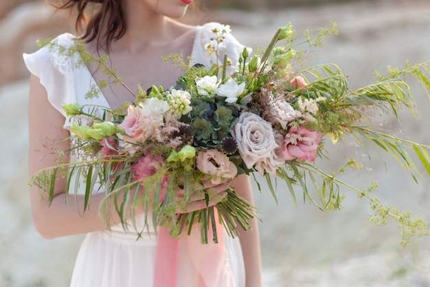 the bride is holding a wedding bouquet of unusual beautiful flowers