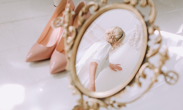 Bride morning dresses touches wedding dress mirror