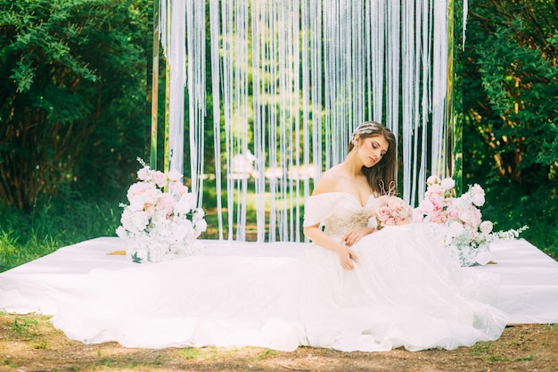 Bride near wedding arch with flowers