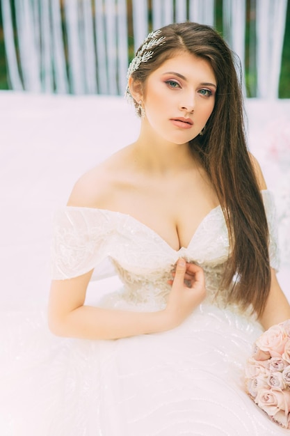 Bride near wedding arch with flowers