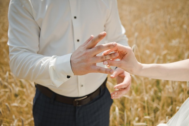 Bride putting a wedding ring on groom's finger. Wedding day .