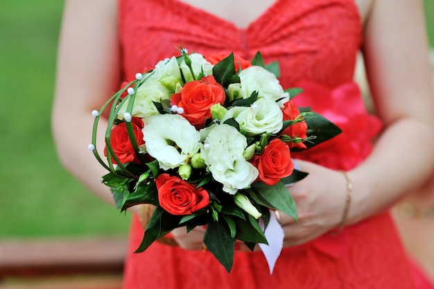 Bride in red dress holding wedding bouquet