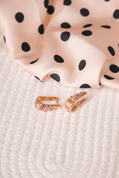 A bride's earrings are displayed on a white background.