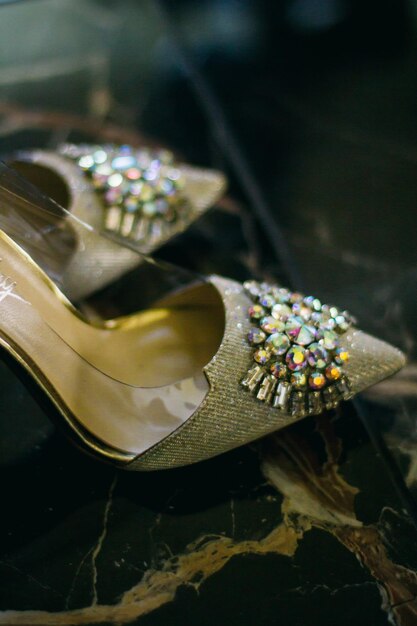 bride's shoes inlaid with precious stones on the marble floor, top view, soft focus