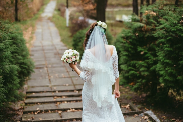 Bride walks holding wedding bouquet in her hands