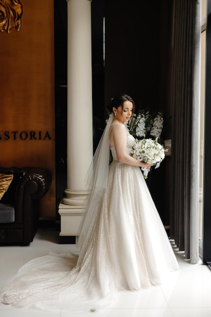 a bride in a wedding dress stands in front of a large doorway