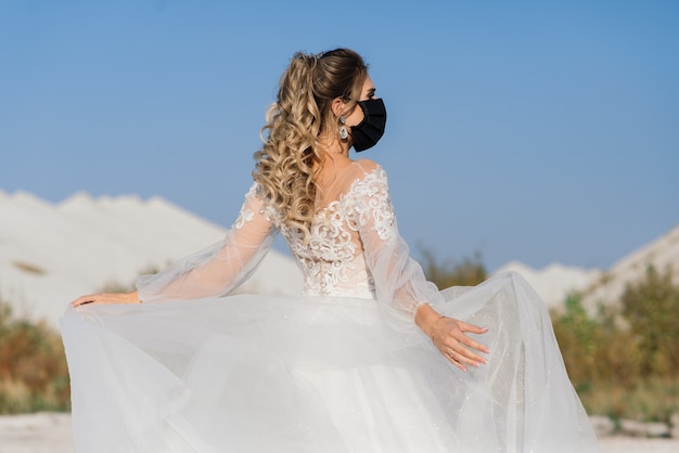 Bride in wedding dress with medical mask at coronavirus covid-19 quarantine period.