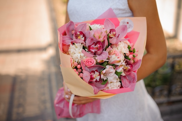 Bride in white dress holding a beautiful bouquet of flowers