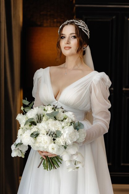 Photo a bride in a white dress holding a bouquet of flowers