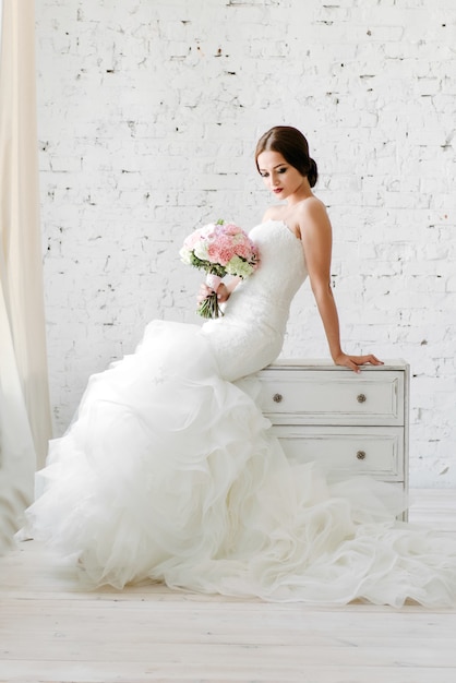 bride in a white dress and holding a bouquet