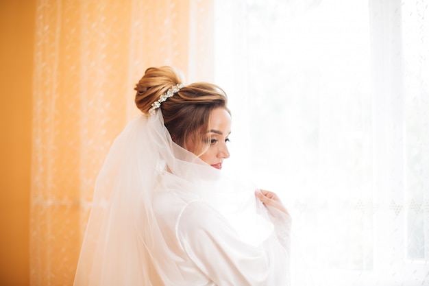 Bride in white dress posing while preparing for the wedding ceremony