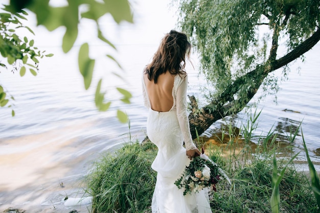 Bride in a white dress walking in the woods by the sea beach wedding concept