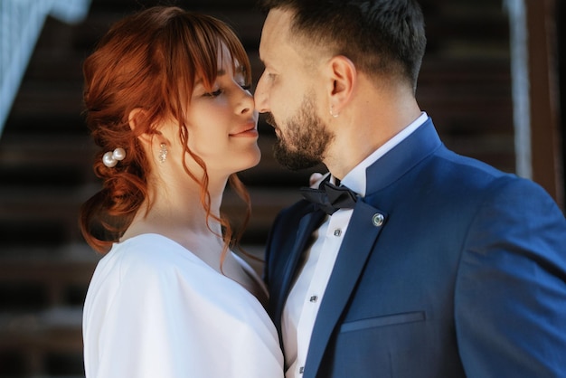 Bride in a white dress with a bouquet and the groom in a blue suit