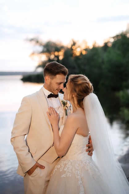 Bride in a white puffy dress and the groom in t on the river bank