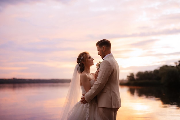 Bride in a white puffy dress and the groom in t on the river bank