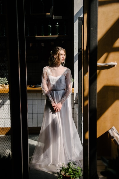 Bride in white wedding dress posing indoors