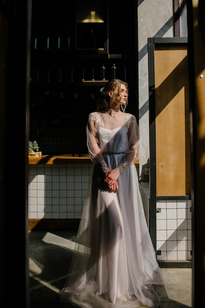 Bride in white wedding dress posing indoors