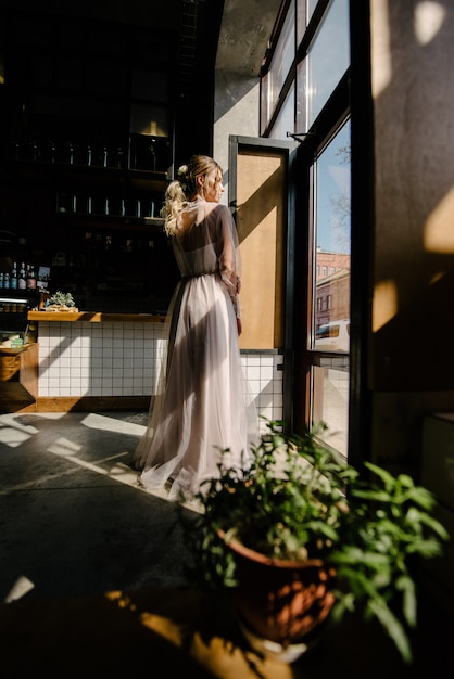 Bride in white wedding dress posing indoors