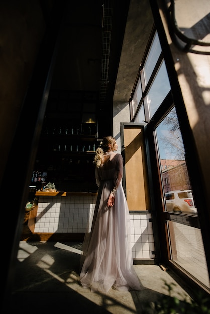 Bride in white wedding dress posing indoors