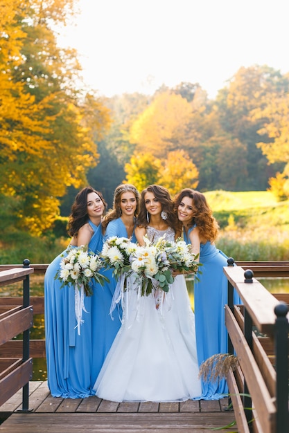 Bride with bridesmaids in the park on the wedding day