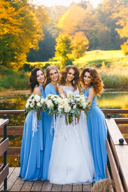 Bride with bridesmaids in park on the wedding day