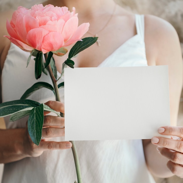 Bride with a coral sunset peony and a wedding invite