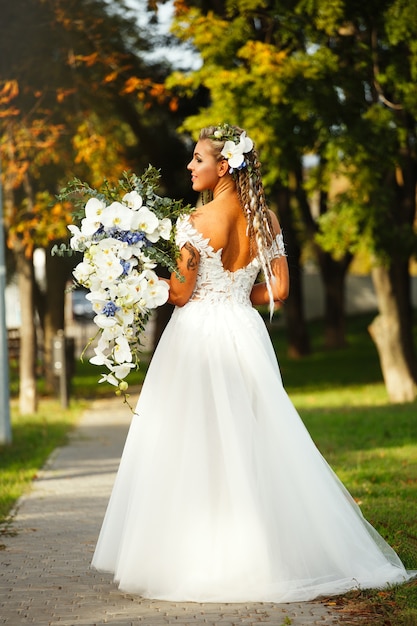 Bride with a gorgeous bouquet in the park