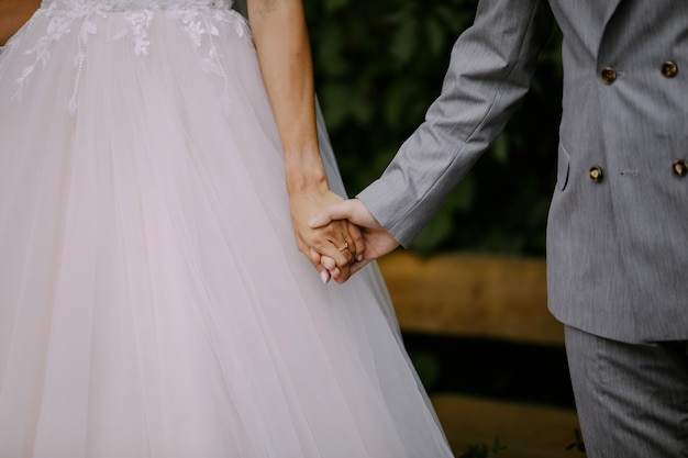 the bridegroom holds the bride by the hand. close-up photo. soft focus