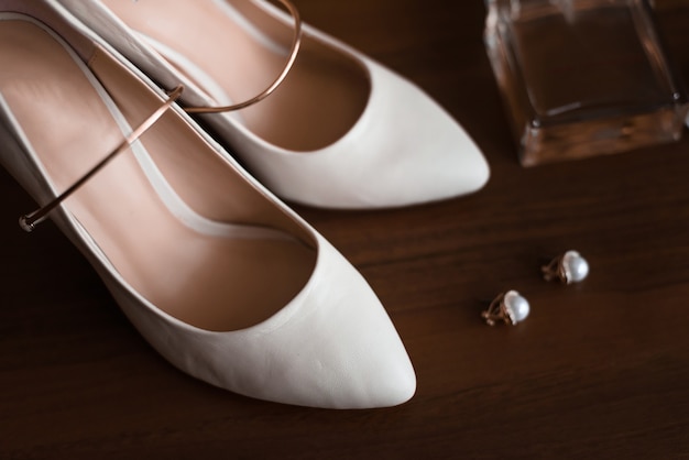 Bridesmaid shoes with aksessuarami stand on a brown table