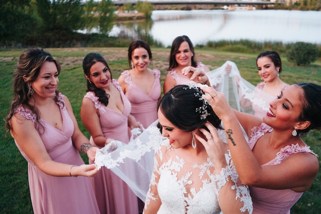 Bridesmaids of the bride placing the bride's veil