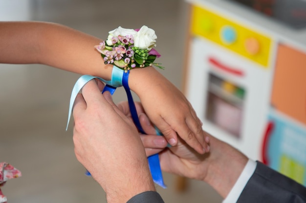 Bridesmaids Hands or child girl daughter are decorated with flower bracelets in wedding day