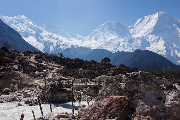 Bridge against the backdrop of snowcapped mountain peaks in the Himalayas Manaslu region