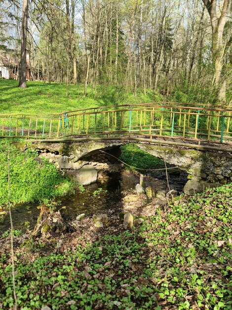 A bridge in a field with a creek in the background