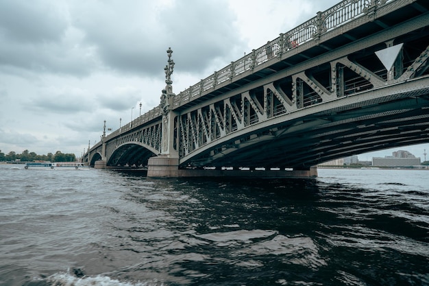 Bridge A low metal bridge across the river in cloudy weather in gloomy dark colors St Petersburg