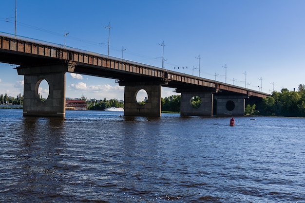 Bridge on a river against a blue sky and clouds