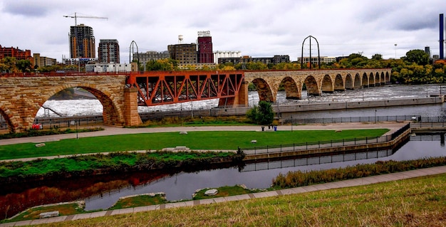 Photo bridge over river in city against sky