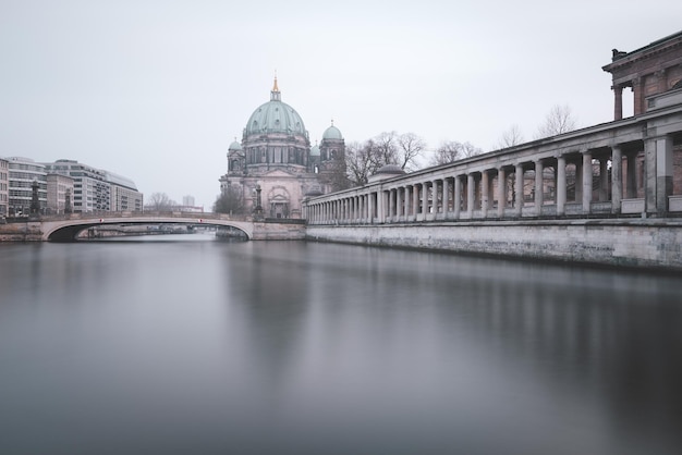 Bridge over spree river by berlin cathedral against sky in city