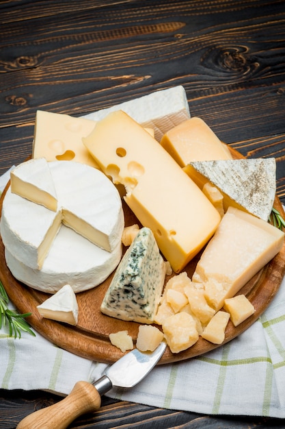 brie, camembert, roquefort and cheddar on wooden board