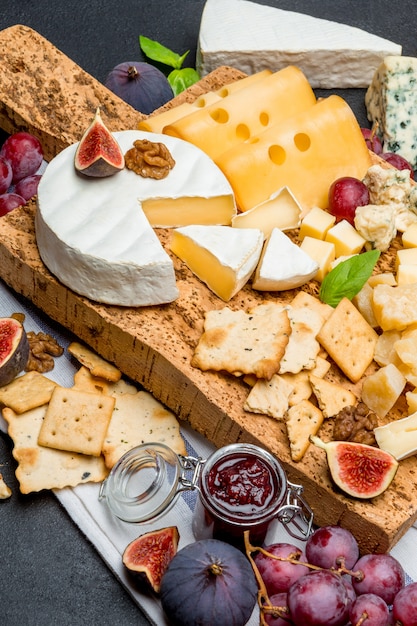 brie, camembert, roquefort and cheddar on wooden board