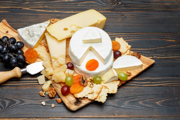 Brie cheese on a wooden Board with fresh figs and grapes