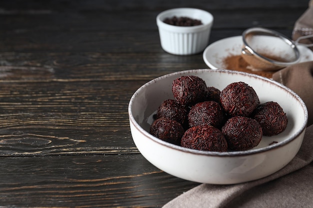 Brigadeiro in bowl on wooden background space for text