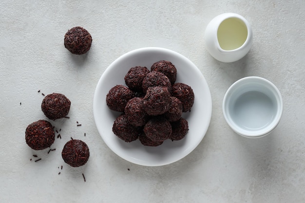 Brigadeiro and bowls on white background top view