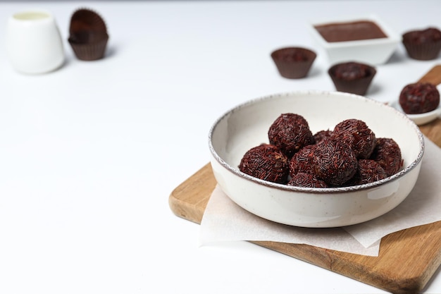 Brigadeiro on plate and kitchen board on white background space for text