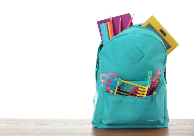 Bright backpack with school stationery on white background