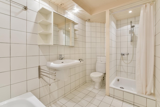 Bright bathroom with white tilesbathtub shower toilet and sink in a cozy private house